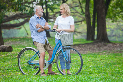 Man with bicycle on sidewalk against plants