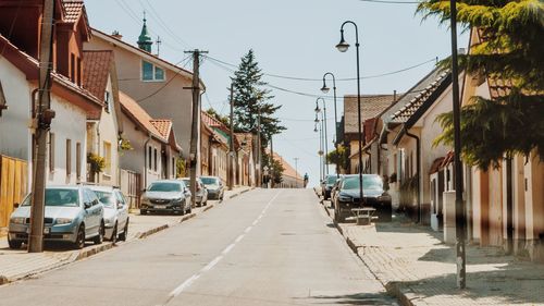 View of road amidst cars and buildings in town