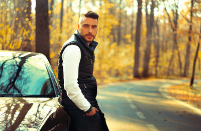 Young man wearing sunglasses standing in forest