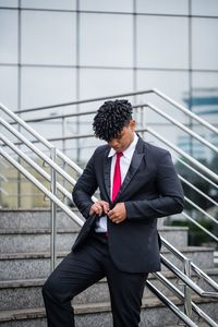 Full length of a man with umbrella on railing