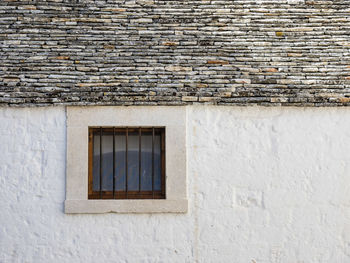 Low angle view of window on brick wall of building