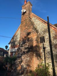 Low angle view of bell tower against blue sky