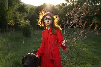 Portrait of woman with dog on land