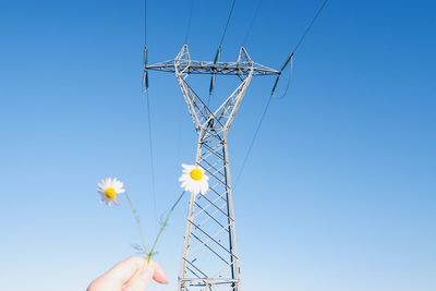 Low angle view of person hand against blue sky