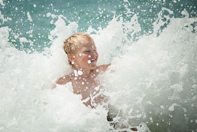 Boy enjoying in water at beach