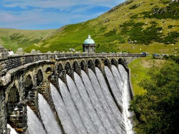 View of dam against sky with mountain in background