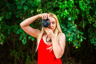 Portrait of woman standing against plants