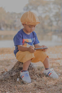 Portrait of boy sitting on field