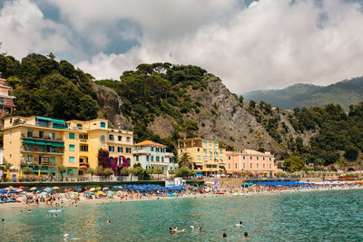 Buildings by sea against sky