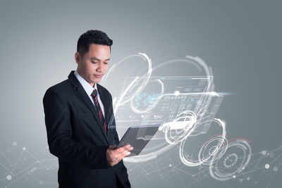 Digital composite image of well-dressed businessman using digital tablet with icons