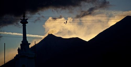 Low angle view of silhouette buildings against sky at sunset