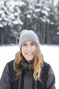 Woman smiling in the snow in the forest