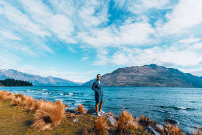 Man standing in sea against sky