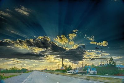 Illuminated road by mountain against sky at night