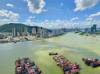 High angle view of boats in river against buildings