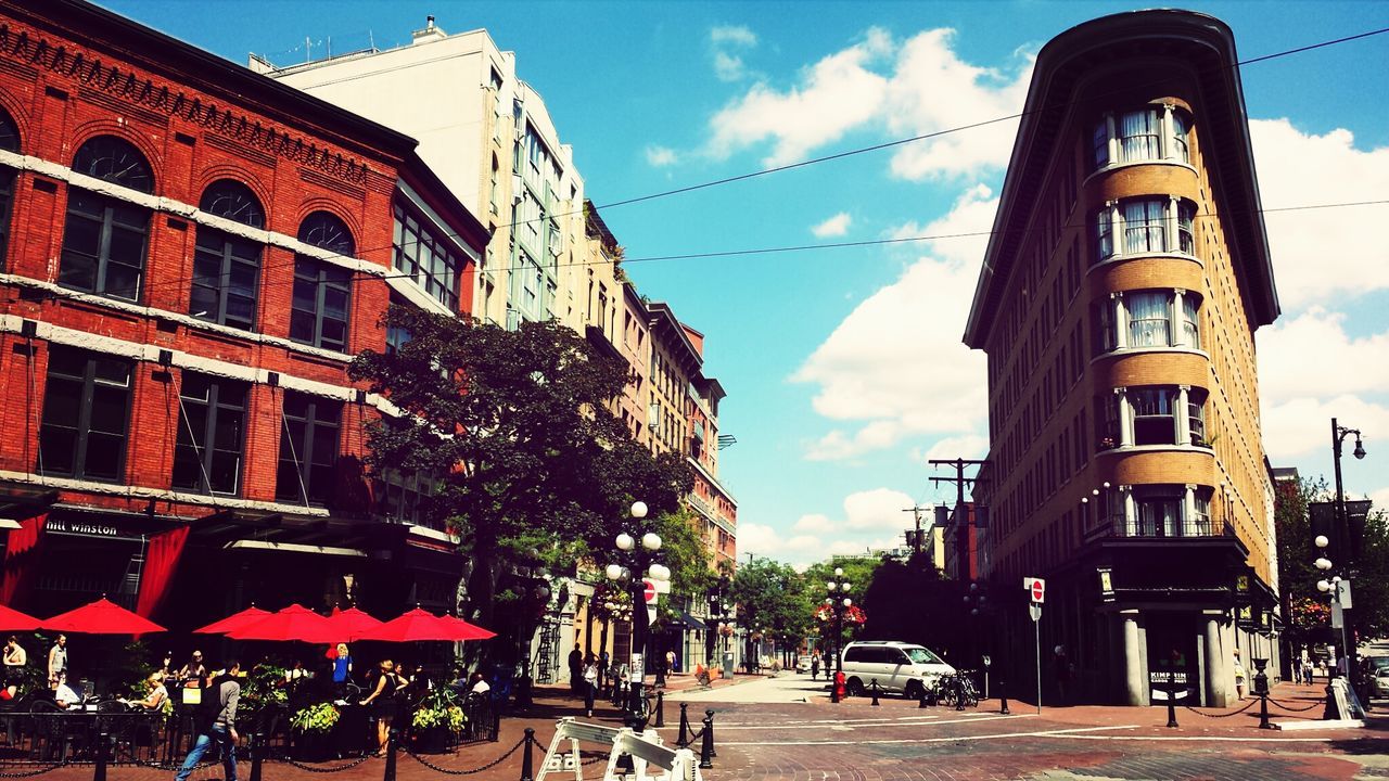 building exterior, architecture, built structure, sky, street, city, car, residential building, transportation, land vehicle, cloud - sky, cloud, street light, building, residential structure, city life, incidental people, road, low angle view, city street