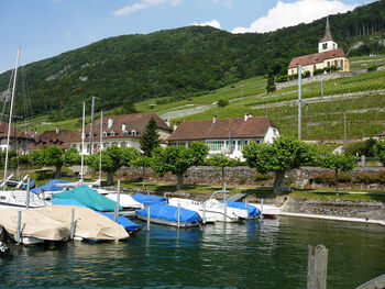 Boats moored in lake against mountain