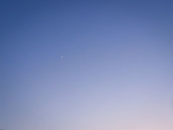 Low angle view of moon against clear blue sky