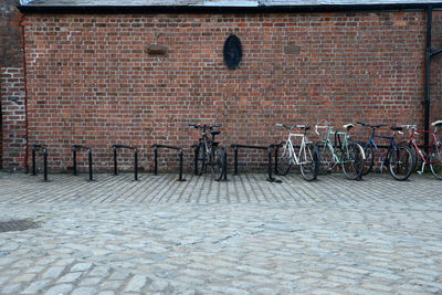 Bicycle parked on footpath against brick wall