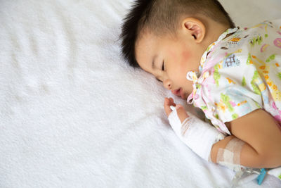 High angle view of baby sleeping on bed