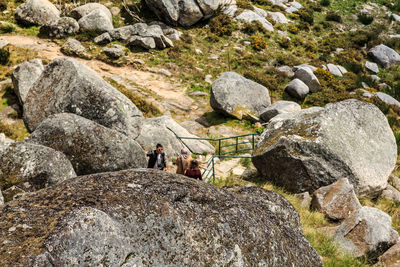 Men standing on rock against sky