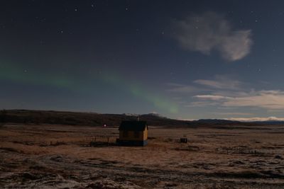 Built structure on field against sky at night