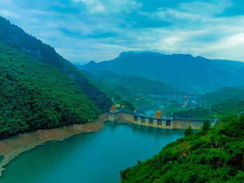 Scenic view of river and mountains against sky