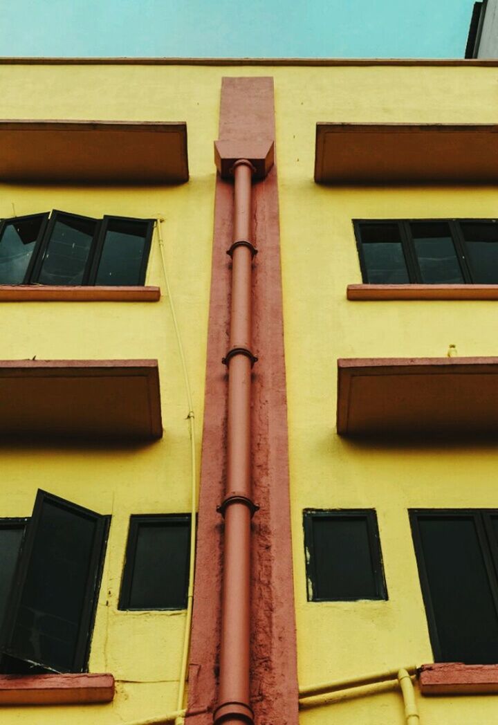 building exterior, low angle view, architecture, built structure, window, yellow, outdoors, no people, day, city, sky, close-up