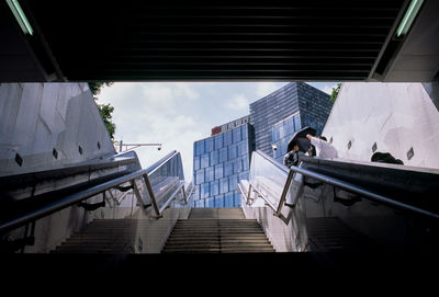 Low angle view of staircase amidst buildings in city against sky