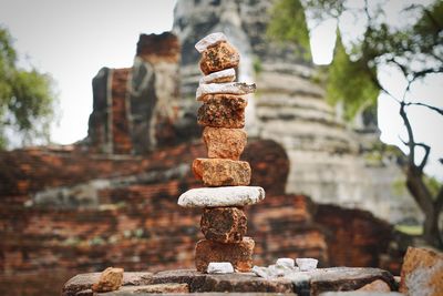 Close-up of rusty stack against stone wall