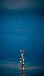 Low angle view of communications tower against blue sky