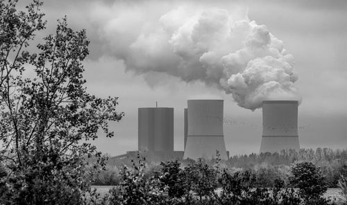 Smoke emitting from chimney against sky