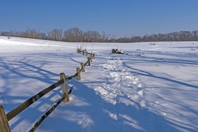 Scenic view of snow covered field against sky