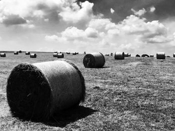 Hay bales on field against sky