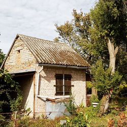 Exterior of old house on field against sky