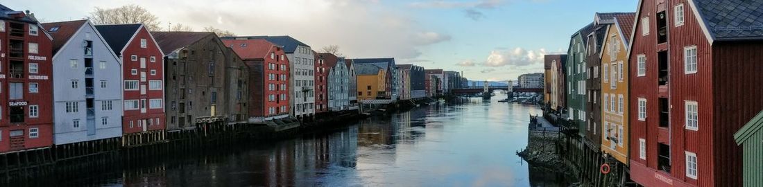 Panoramic view of canal amidst buildings against sky