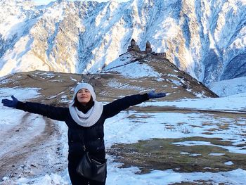 Rear view of woman standing on snow covered mountain