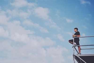 Low angle view of woman standing against sky