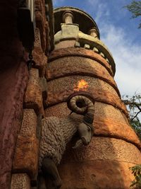 Low angle view of buddha statue against sky