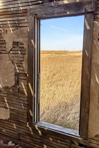Scenic view of field against sky seen through window