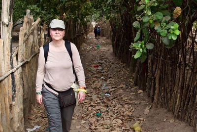 Portrait of smiling woman standing against trees