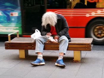 Full length of woman sitting on bench