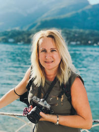 Portrait of a smiling woman against sea