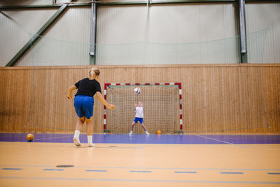 Female handball players playing with ball in sports court