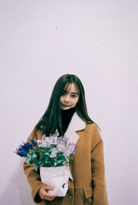 Young woman standing against white background