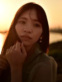 Portrait of beautiful woman against sky during sunset