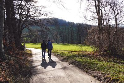 Rear view of woman walking on footpath