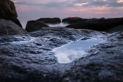 Close-up of river against sky during sunset