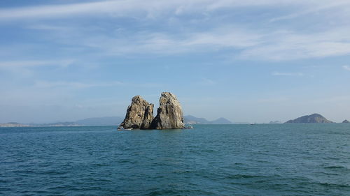 Scenic view of rock formation in sea against sky