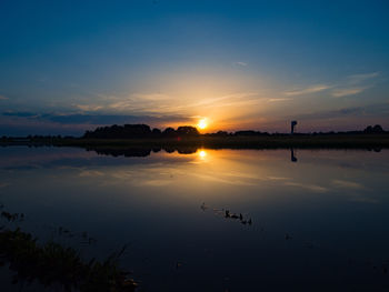 Scenic view of lake against sky during sunset